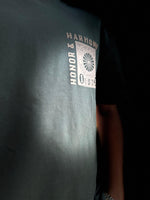 Load image into Gallery viewer, Close-up of Honour and Harmony hunter green oversized men’s t-shirt front graphic with non-PVC ink print detail”