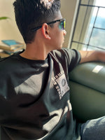 Load image into Gallery viewer, Honour and Harmony hunter green oversized men’s t-shirt styled on model as sustainable fashion everyday casual look”