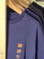 Load image into Gallery viewer, A detail shot of Humble Human navy blue oversized men’s t-shirt front view on hanger