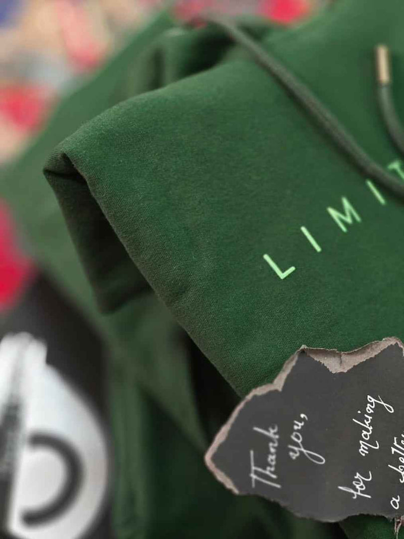 Close-up of Limitless hunter green hoodie front print with partial Limitless text graphic in non-PVC ink