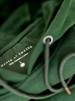 Load image into Gallery viewer, Close-up of Limitless hunter green hoodie hood and drawstrings showing fabric texture and stitching
