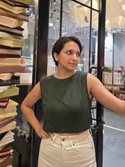 Model standing in a store with shelves of books  in the background wearing House of SwaSha Ebony Green Bamboo Tank Top