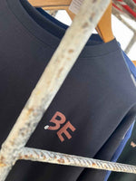 Load image into Gallery viewer, Close-up of the BeLeaver Charcoal Black tee on a hanger - front shot