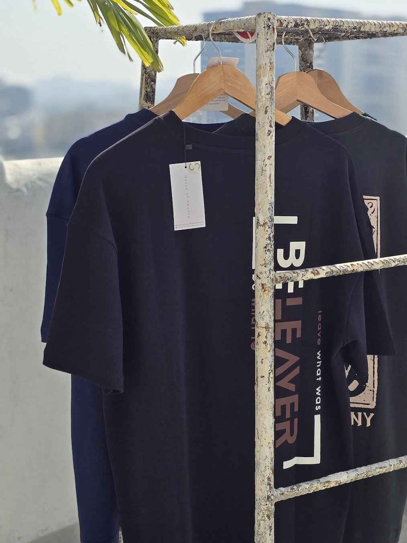 Side angle of BeLeaver charcoal black oversized men’s t-shirt in natural light highlighting the back print 