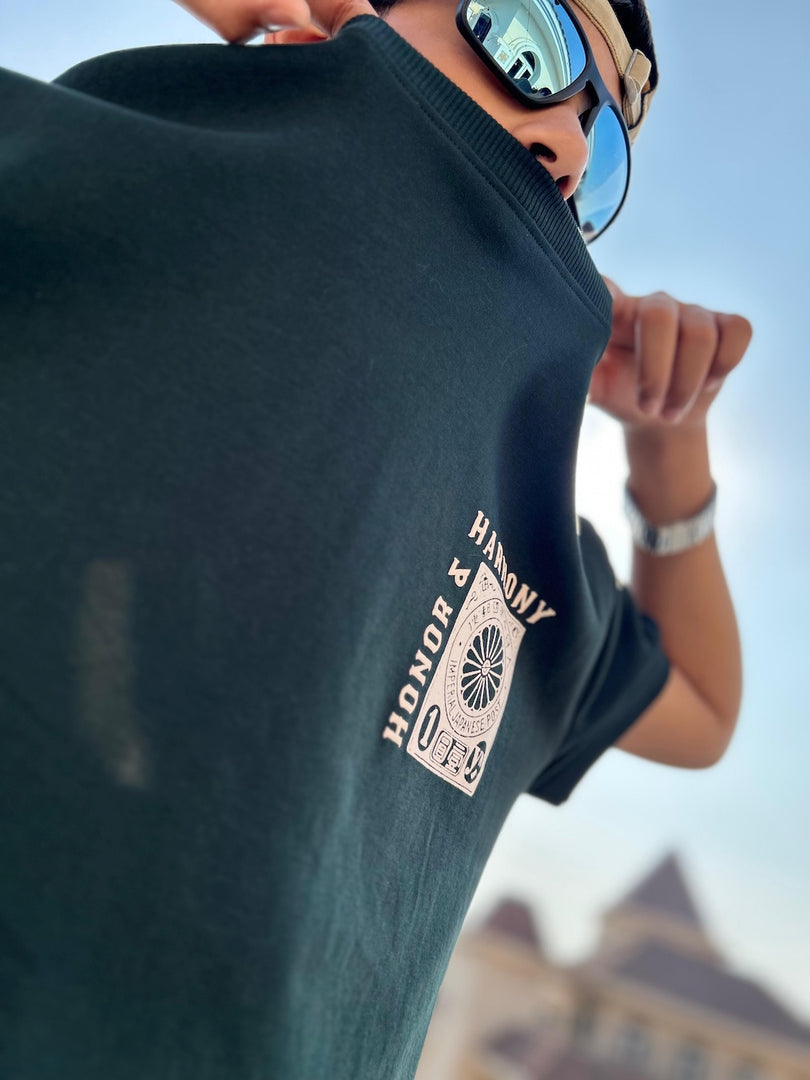 Honour and Harmony hunter green oversized men’s t-shirt three-quarter front angle on model highlighting chest graphic