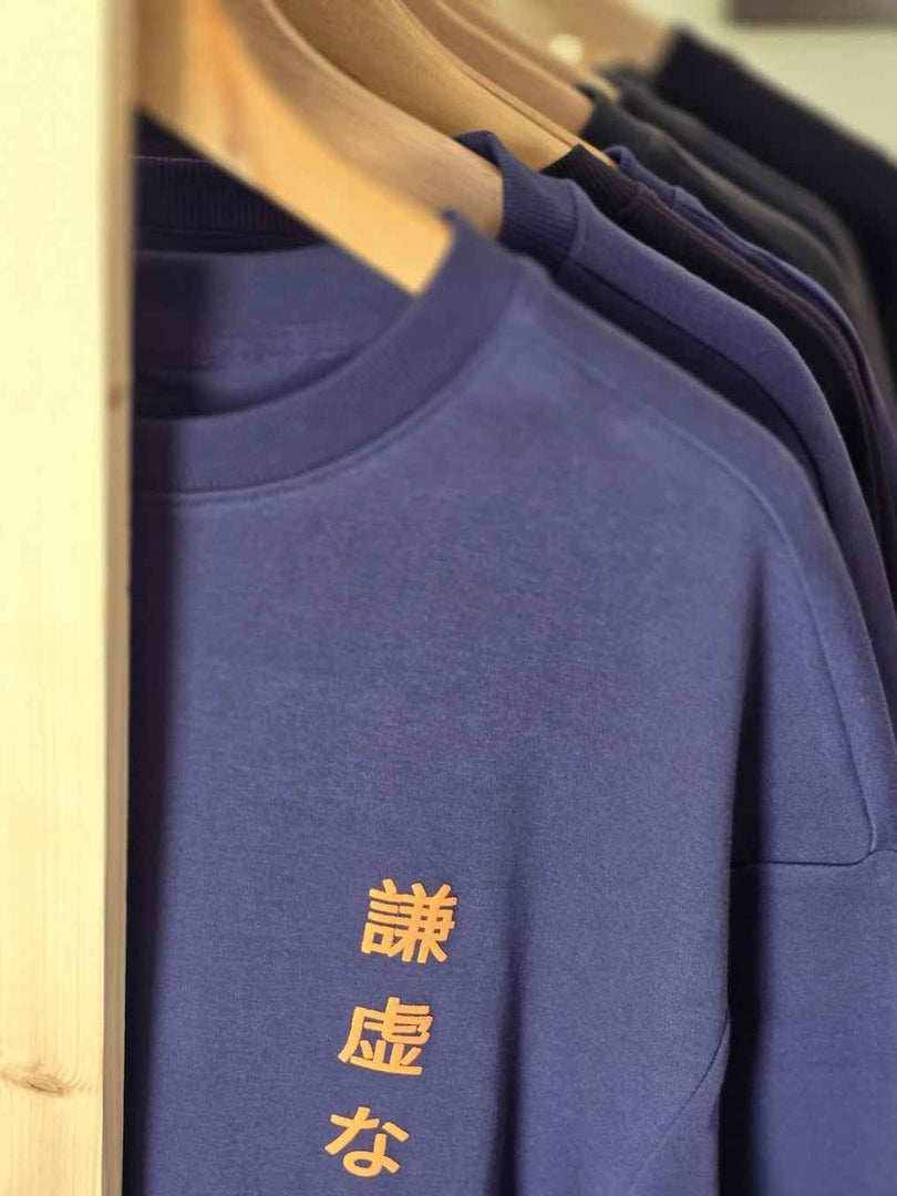 A detail shot of Humble Human navy blue oversized men’s t-shirt front view on hanger