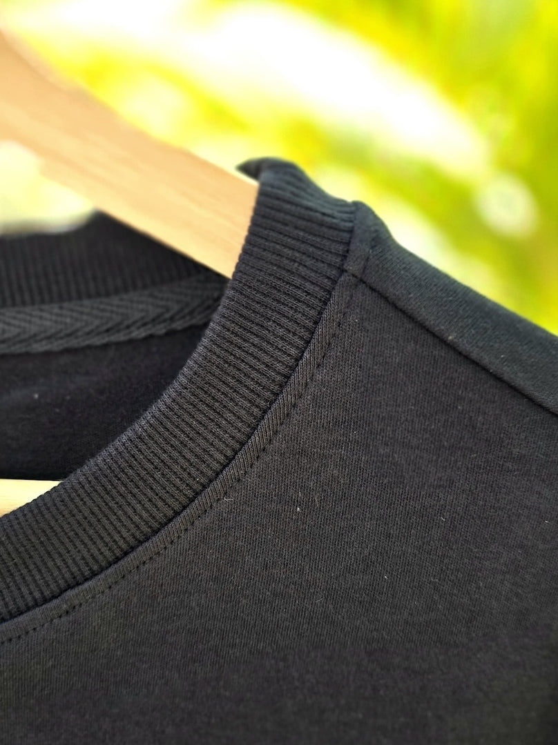 Close-up of Spirited Soul The Monk charcoal black oversized men’s t-shirt highlighting stretchable collar