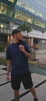 Load and play video in Gallery viewer, House of SwaSha navy blue oversized men’s t-shirt on model in motion highlighting fabric flow